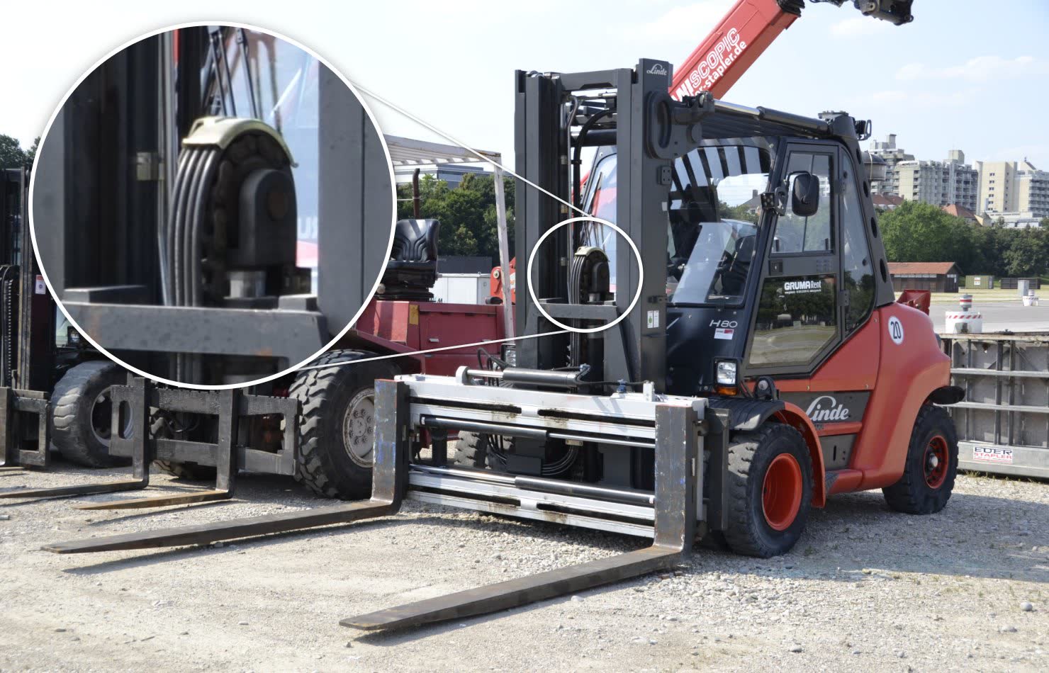 Dây ống đen vắt qua bánh dẫn trên khung nâng xe nâng, phóng to trong vòng tròn